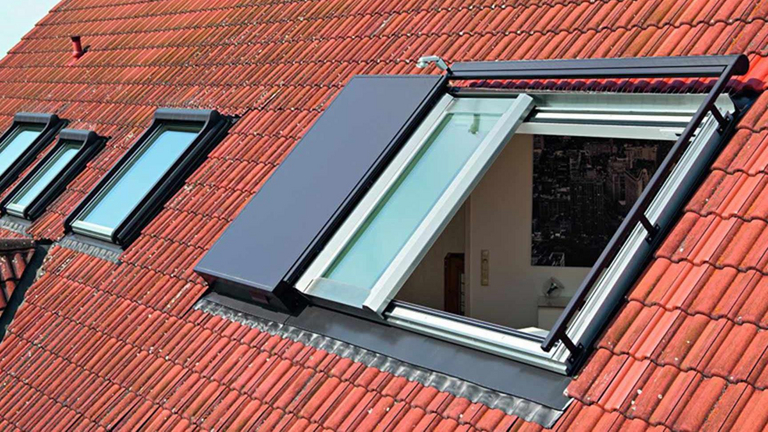Panorama-Dachschiebefesnter geöffnet in einem Dach mit mehreren Dachfenstern im Hintergrund