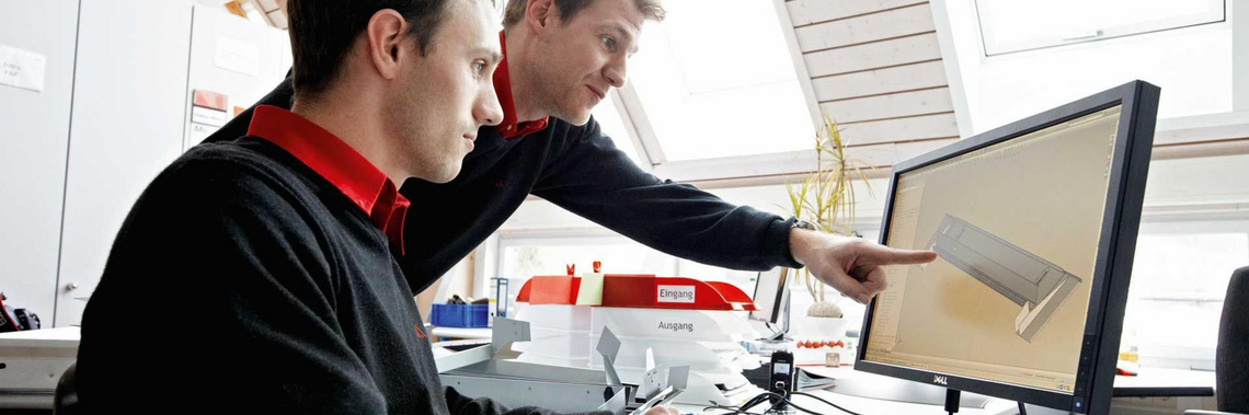Zwei Männer besprechen an einem Computer ein 3D-Modell