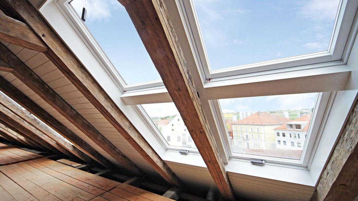 Dachgeschoss mit alten Holzbalken und mehreren Dachfenstern 