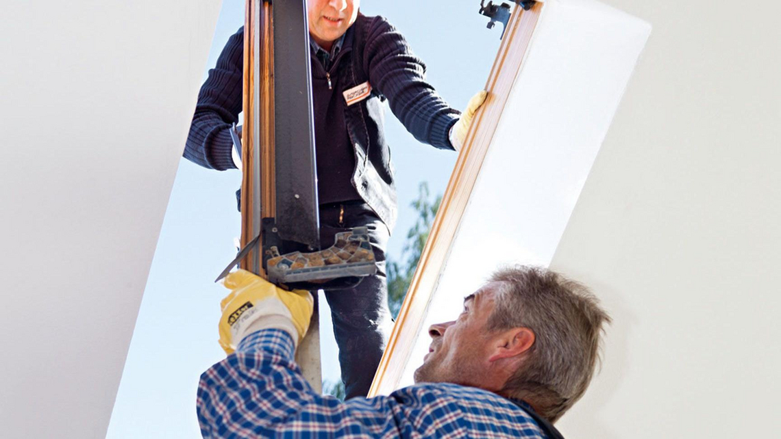 Zwei Handwerker beim Einbau von einem Maß-Renovierungsfenster
