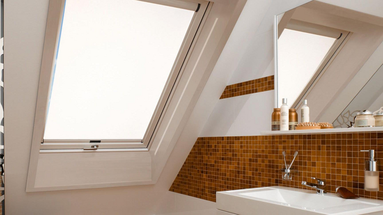 Badezimmer mit einem Dachfenster und geschlossenen Tageslichtrollo