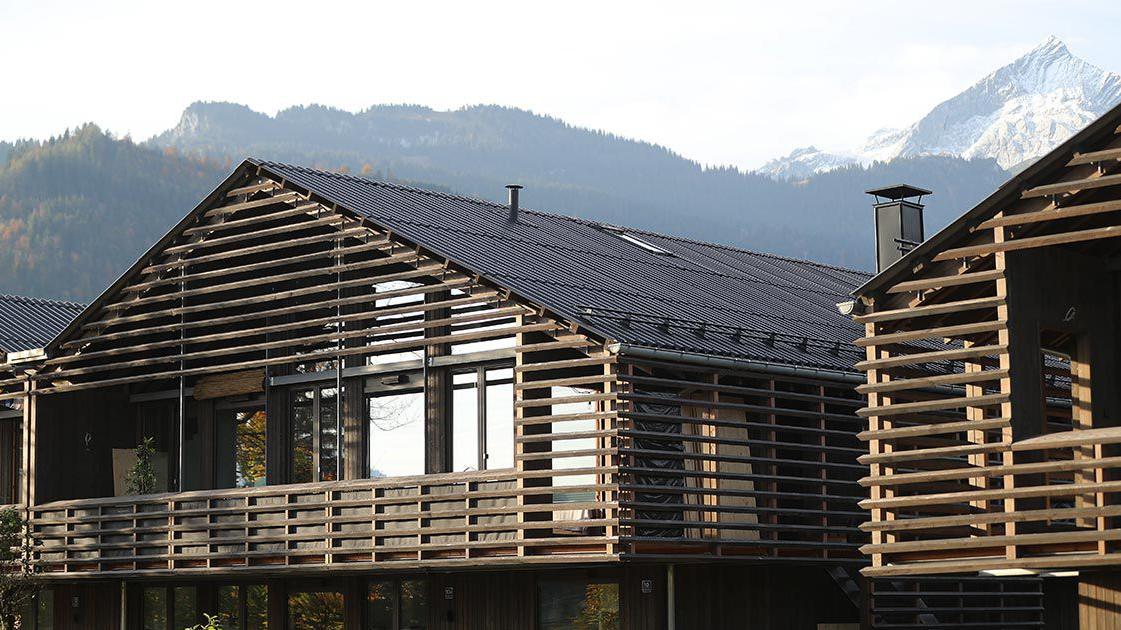 Zwei Holzhäuser mit Bergen im Hintergrund